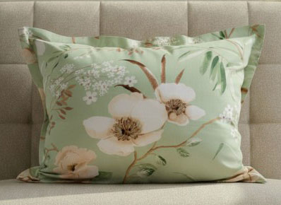 възглавница с калъфка с магнолии върху легло
